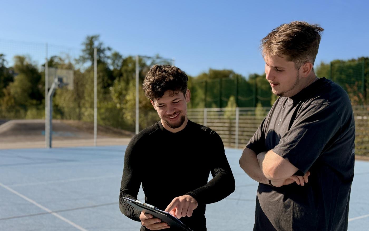 Felix Anselm bespricht mit einem Kunden den Trainingsplan auf dem Tablet